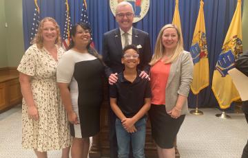 Advocates standing alongside NJ governor for the medical debt bill signing ceremony