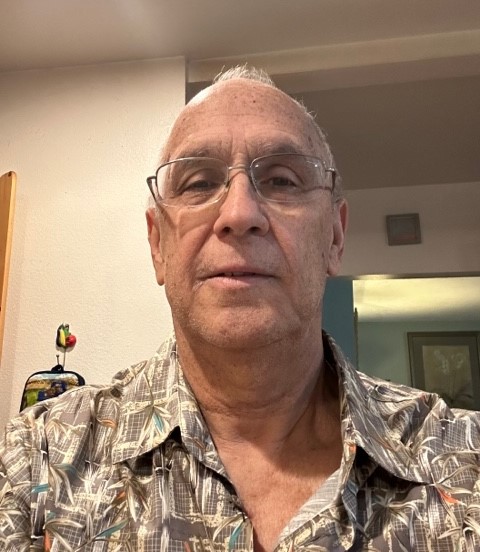 older white man with glasses and balding wearing a grayish patterned shirt