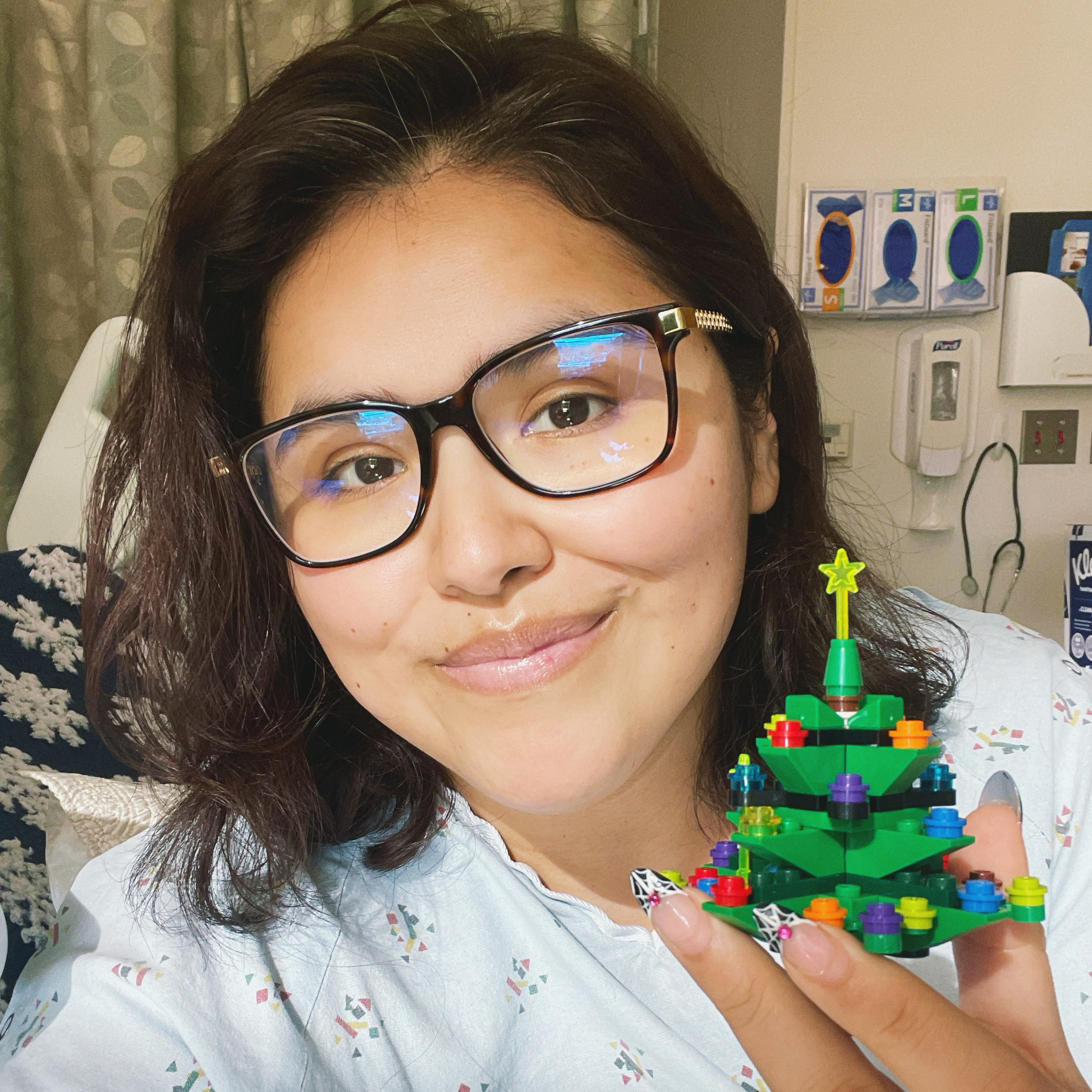 leukemia patient holding a christmas tree lego at the hospital during treatment