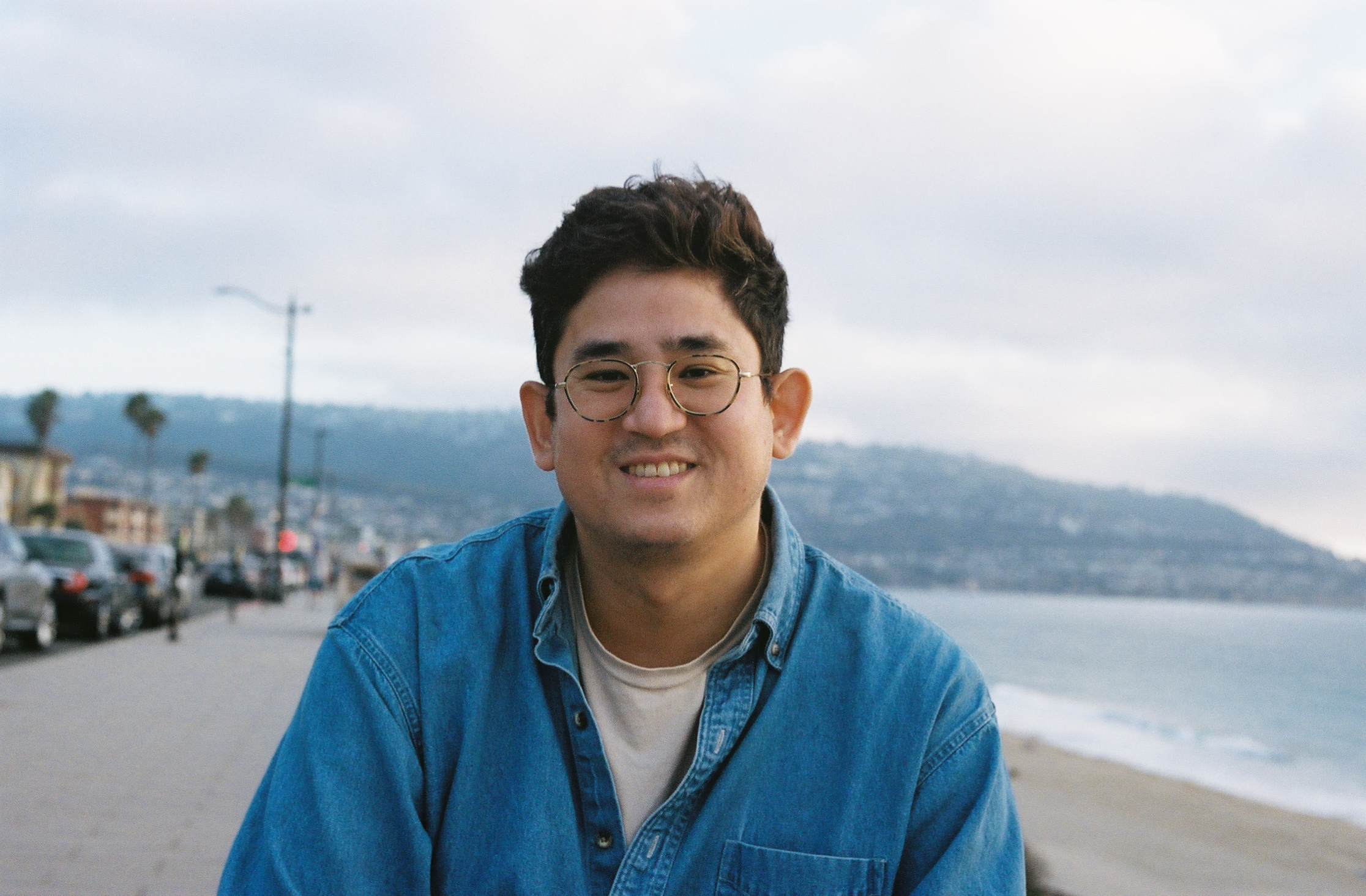 leukemia patient weaing glasses and blue shirt at the beach