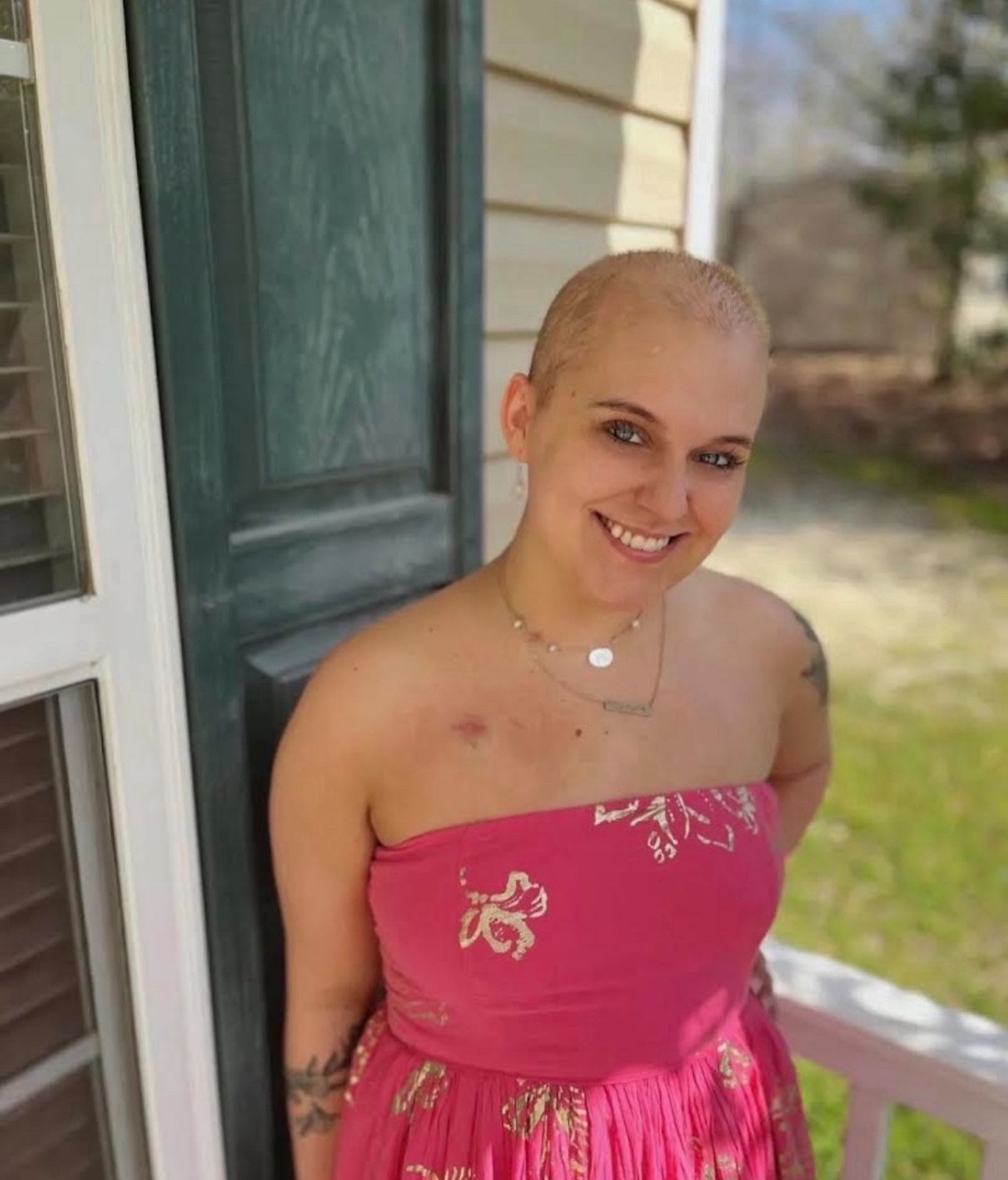 young adult blood cancer survivor with a pink wrap dress and port scar smiling nodular sclerosis Hodgkin lymphoma (NSHL)