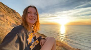 Mollie sitting next to a body of water