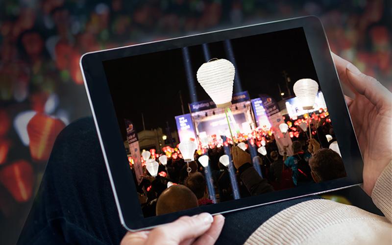 a person watching an event on a tablet