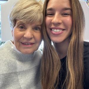 older woman with short blond hair in a sweater next to younger woman with long brown hair and a black shirt