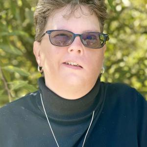chronic myeloid leukemia, wearing dark colored shirt with glasses 