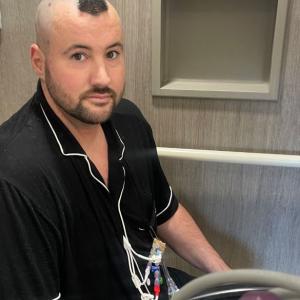 leukemia patient wearing a black shirt in the hospital receiving treatment