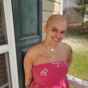 young adult blood cancer survivor with a pink wrap dress and port scar smiling nodular sclerosis Hodgkin lymphoma (NSHL)