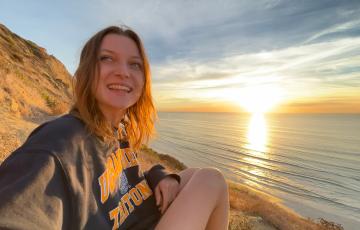 Mollie sitting next to a body of water