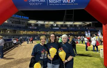 three white women holding gold balloons middle one with glasses all wearing LTN tshirts